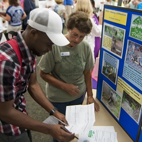 Photo of a student talking to a community partner Photo of a student talking to a community partner